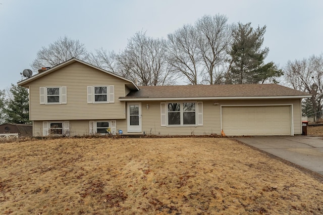 split level home with concrete driveway and an attached garage