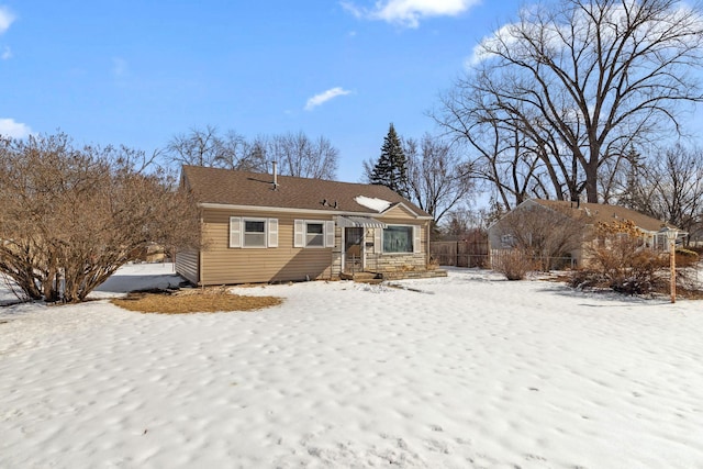 view of snow covered back of property