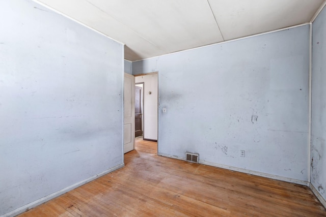 spare room featuring visible vents and hardwood / wood-style flooring