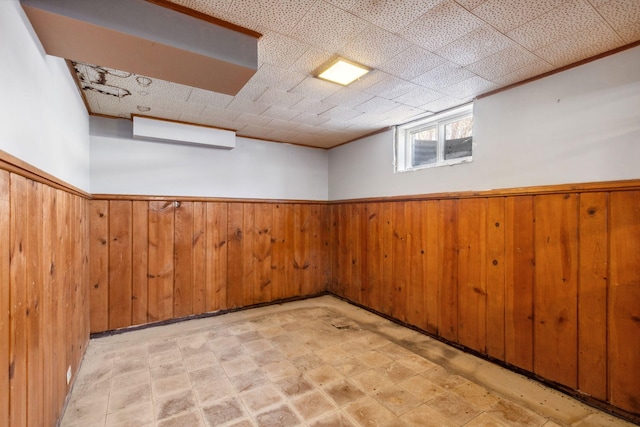 basement with wooden walls and a wainscoted wall