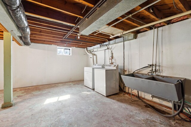 basement featuring washing machine and clothes dryer and a sink