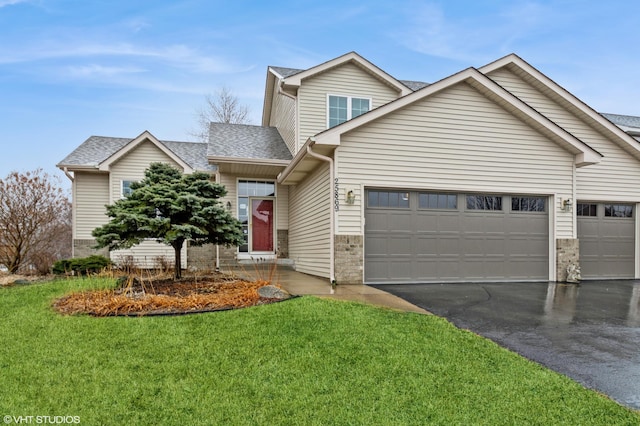 view of front of home featuring a garage, a front yard, roof with shingles, and aphalt driveway