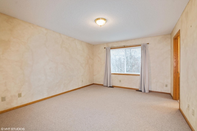 unfurnished room featuring a textured ceiling, baseboards, and light colored carpet