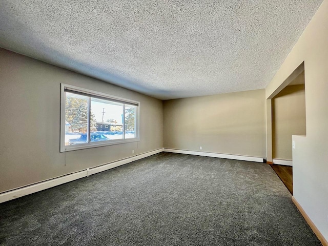 spare room featuring baseboards, dark carpet, and a textured ceiling