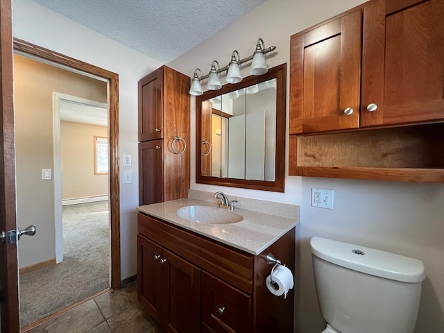 bathroom featuring baseboards, toilet, a textured ceiling, and vanity