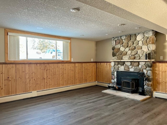 unfurnished living room with a baseboard radiator, a textured ceiling, and wainscoting