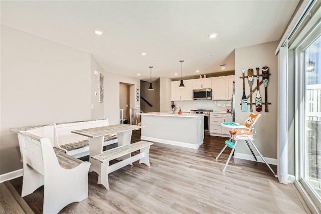 dining space with recessed lighting, light wood-type flooring, and baseboards