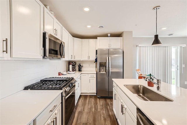 kitchen with white cabinetry, stainless steel appliances, a sink, and light countertops