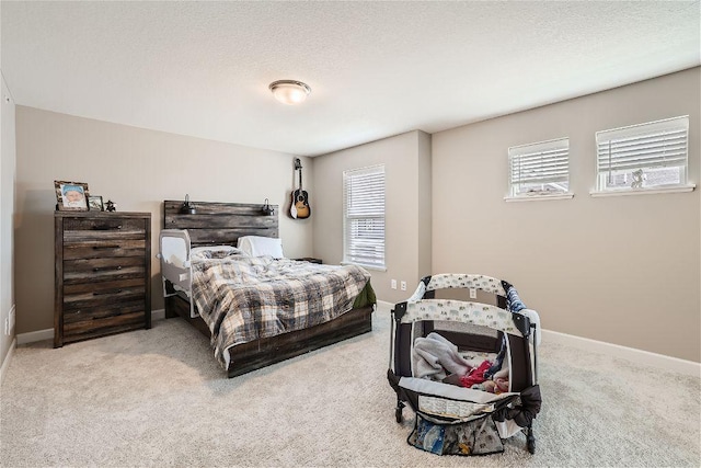 bedroom with carpet flooring, a textured ceiling, and baseboards