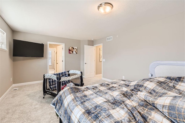 bedroom with light carpet, visible vents, and baseboards