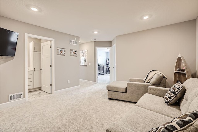 living area featuring light carpet, visible vents, and baseboards