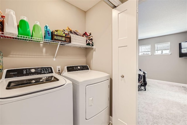 clothes washing area with carpet floors, laundry area, baseboards, and separate washer and dryer