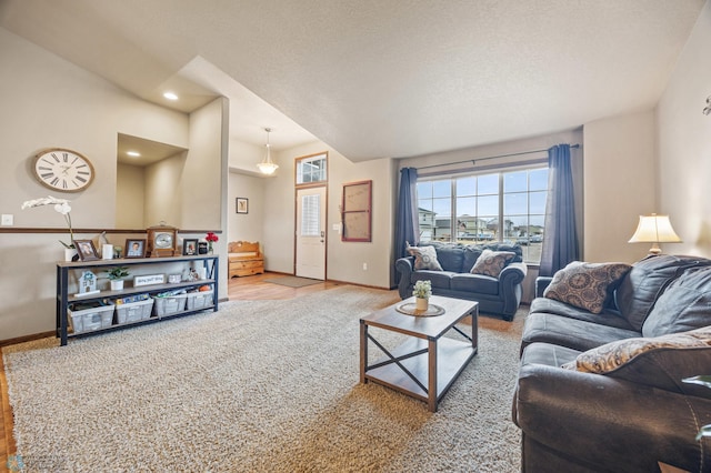 living area with a textured ceiling, carpet flooring, and baseboards