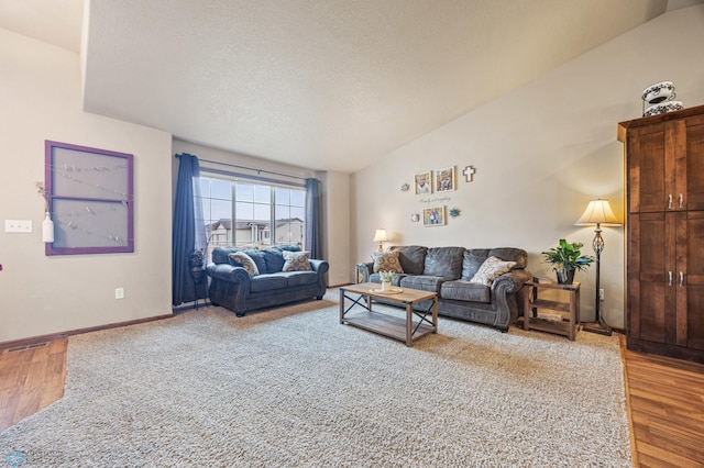 living room with visible vents, vaulted ceiling, a textured ceiling, and wood finished floors