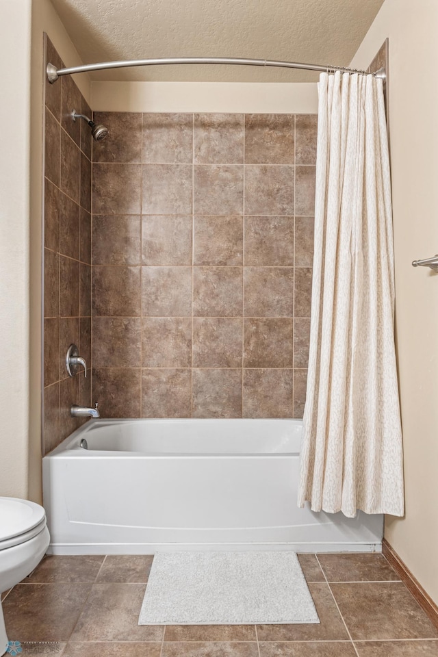 full bathroom featuring a textured ceiling, tile patterned flooring, shower / bath combo with shower curtain, and toilet