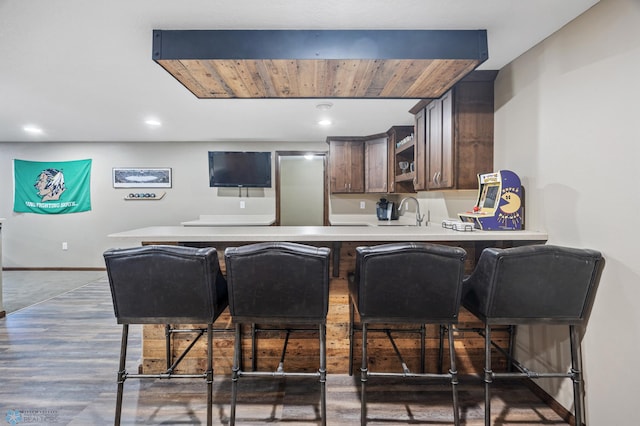 bar with recessed lighting, a sink, baseboards, and wood finished floors