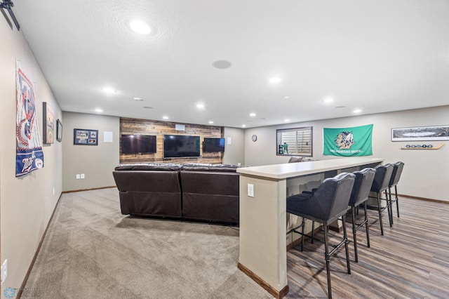 living area featuring recessed lighting, light colored carpet, a dry bar, and baseboards