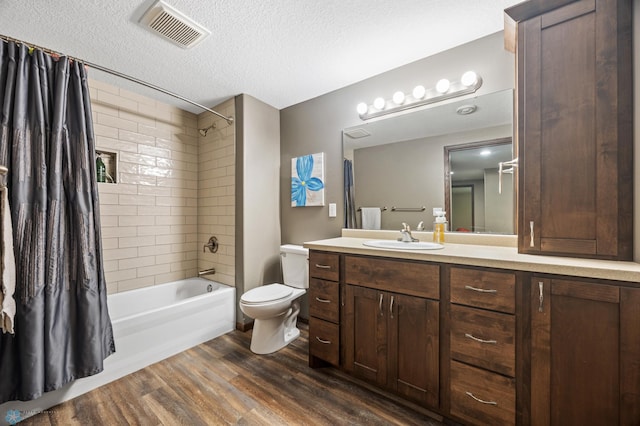 full bath featuring visible vents, toilet, shower / bath combo, a textured ceiling, and wood finished floors