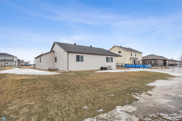 rear view of house featuring a patio, a lawn, and fence