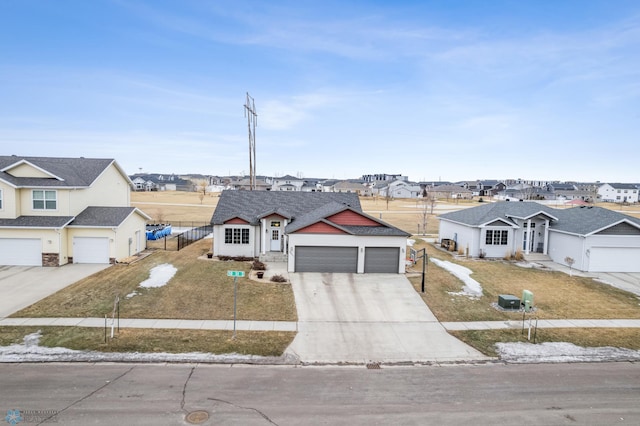 view of front facade featuring a garage, fence, concrete driveway, a residential view, and a front yard