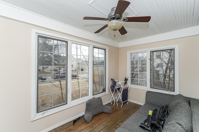 interior space featuring a ceiling fan, plenty of natural light, baseboards, and hardwood / wood-style flooring