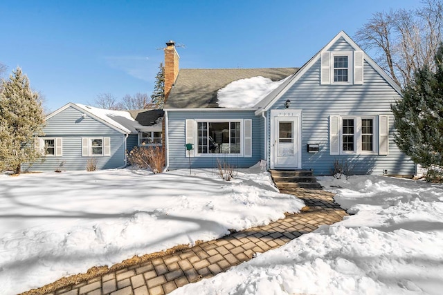 snow covered house with a chimney