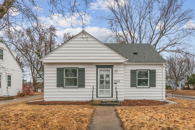 bungalow featuring roof with shingles and a chimney