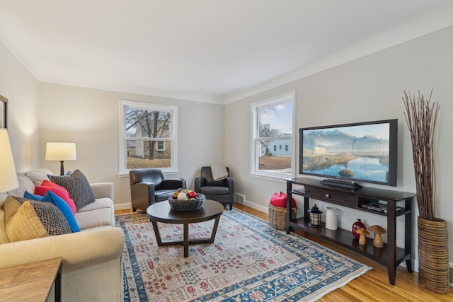 living room with visible vents, baseboards, and wood finished floors