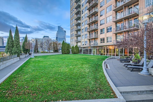 view of property's community with a view of city and a yard