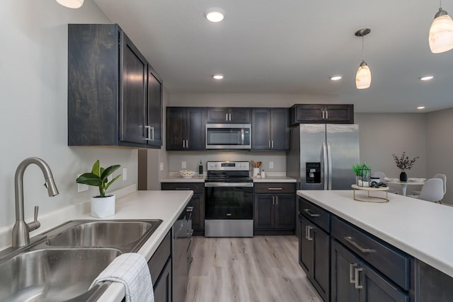 3112 Scotch Ln, Mankato, MN 56001 - kitchen featuring stainless steel appliances, a sink, light countertops, pendant lighting, and light wood-type flooring