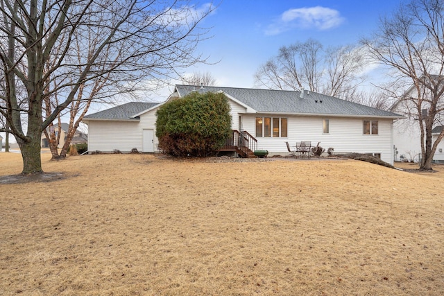 rear view of house featuring roof with shingles