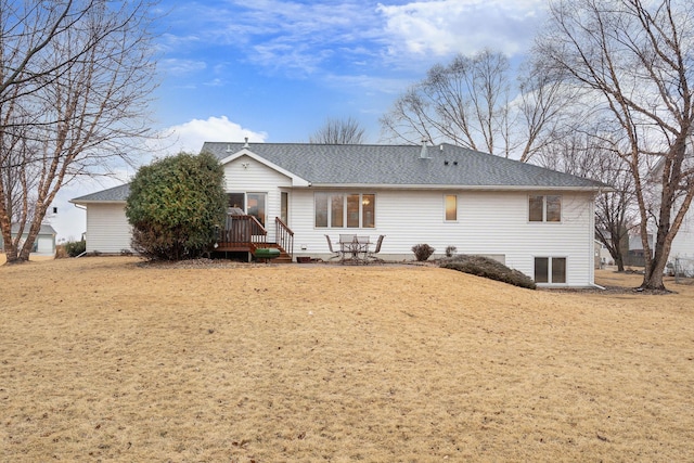 rear view of house featuring a shingled roof and a deck