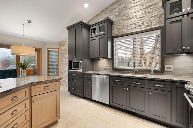 kitchen featuring stainless steel appliances, a wealth of natural light, a sink, and backsplash