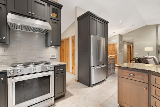 kitchen featuring stainless steel appliances, lofted ceiling, tasteful backsplash, light stone countertops, and under cabinet range hood