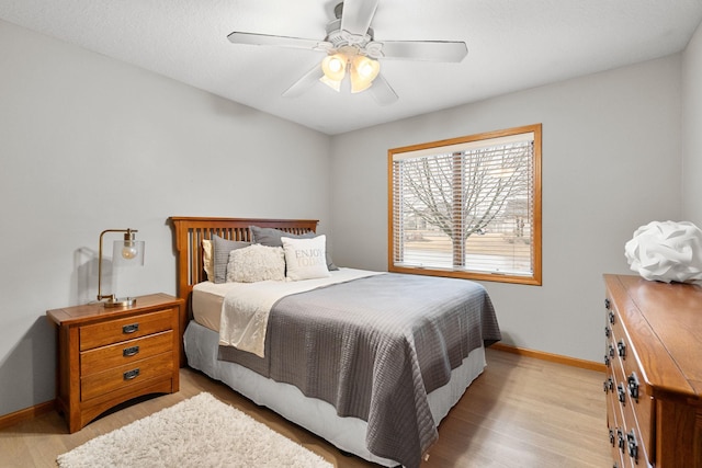 bedroom featuring light wood-style flooring, baseboards, and a ceiling fan