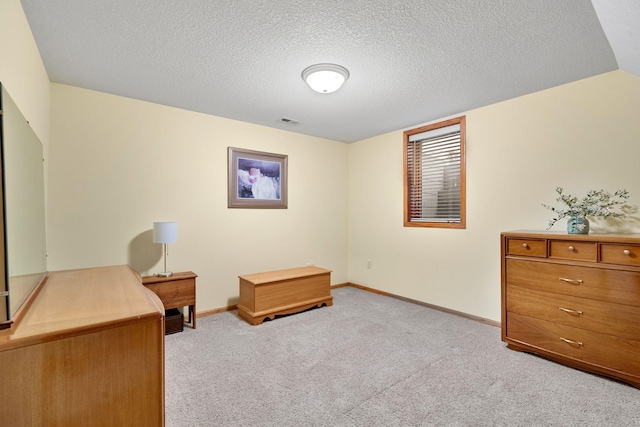 office area with light carpet, baseboards, visible vents, and a textured ceiling