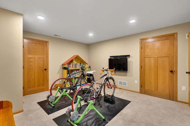 exercise room with carpet, visible vents, and baseboards