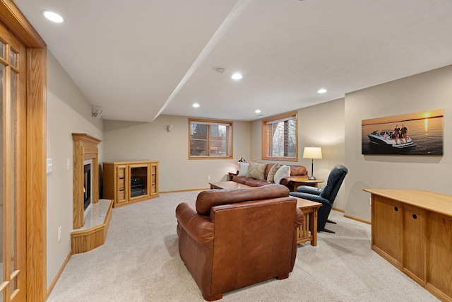 living room with light carpet, baseboards, a fireplace with raised hearth, and recessed lighting