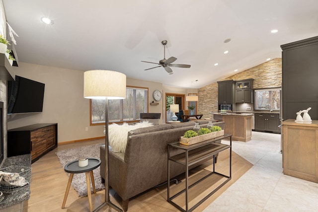 living room featuring lofted ceiling, recessed lighting, ceiling fan, light wood-type flooring, and baseboards