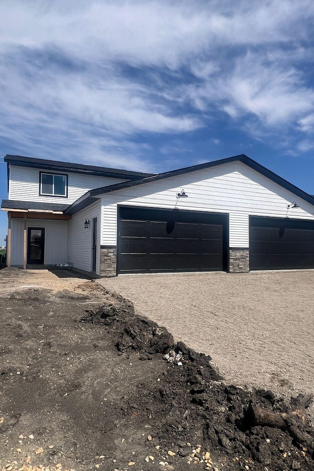 view of front of home with a garage and stone siding