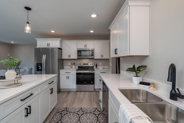 3108 Scotch Ln, Mankato, MN 56001 - kitchen with stainless steel appliances, a sink, white cabinets, decorative light fixtures, and recessed lighting