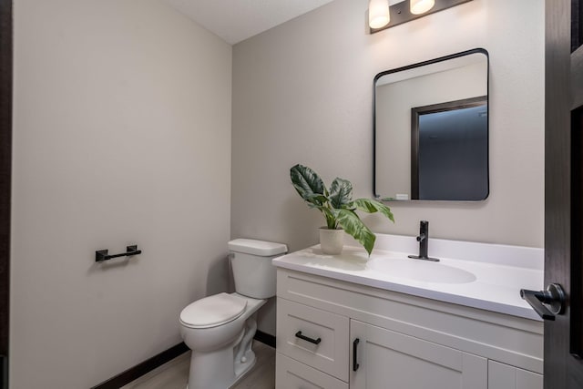 3108 Scotch Ln, Mankato, MN 56001 - bathroom with toilet, vanity, baseboards, and wood finished floors