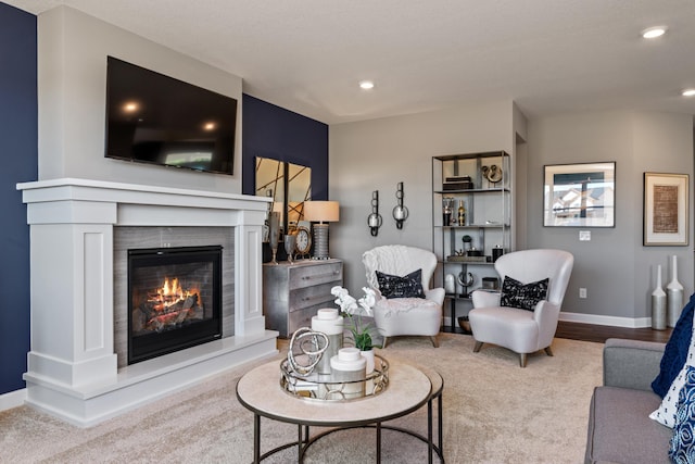 living area with recessed lighting, baseboards, and a glass covered fireplace