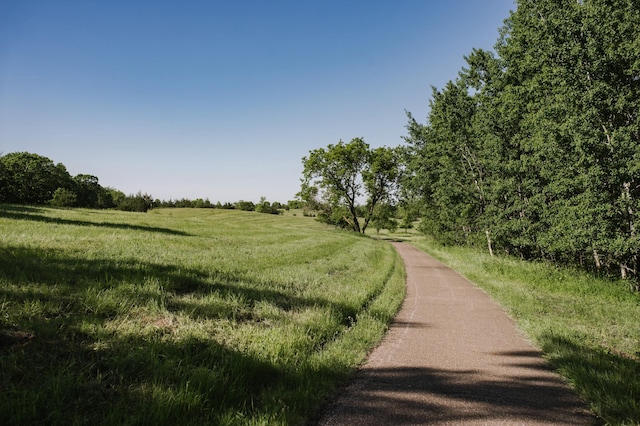 view of property's community featuring a rural view and a lawn