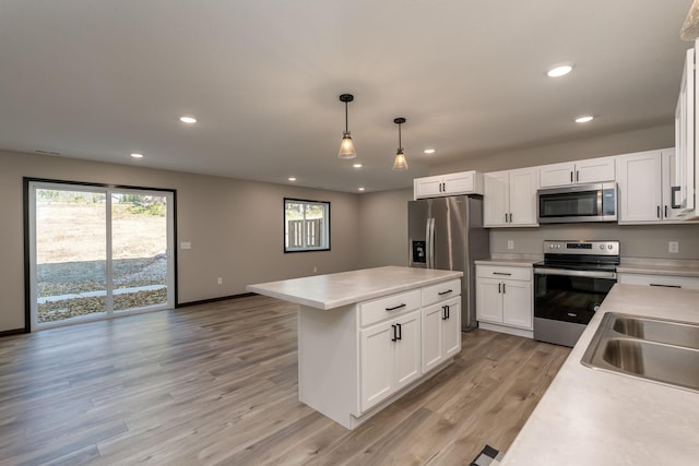 kitchen featuring light wood finished floors, appliances with stainless steel finishes, light countertops, and recessed lighting