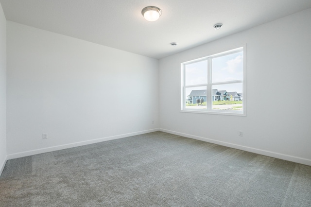 carpeted spare room with baseboards