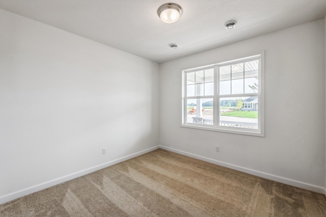 carpeted empty room with baseboards