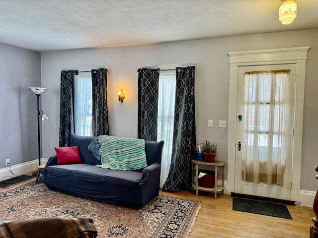 living room featuring plenty of natural light, light wood-style flooring, and baseboards