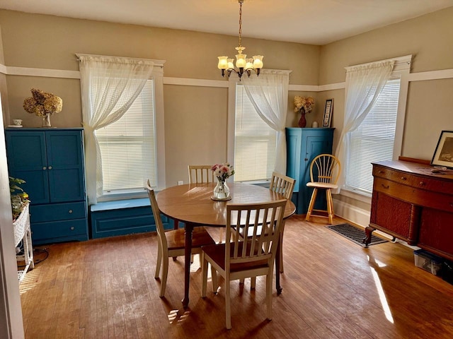 dining space featuring a notable chandelier and wood finished floors