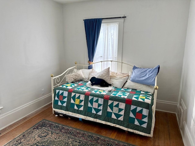 bedroom featuring baseboards, visible vents, and wood finished floors